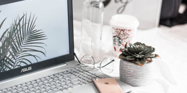 Schreibtisch mit Computer, Arbeitsmaterial und Dekoration