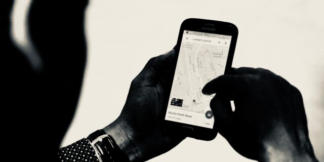 Person hält Handy mit geöffneter Navigationsapp in der Hand