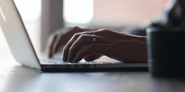 Person tippt etwas auf ihrem Laptop