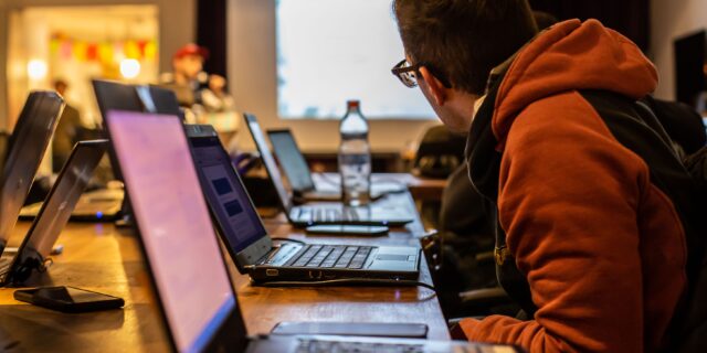 Personen an ihren Laptops in einer Schulung