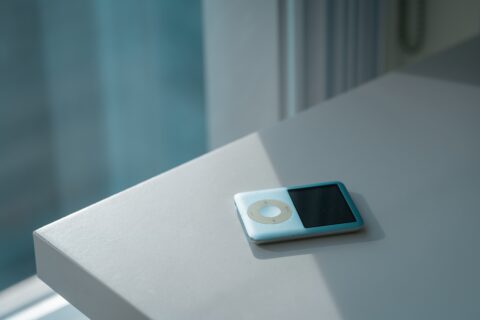 Ipod auf einem Schreibtisch. Durch ein Fenster scheint die Sonne auf den Tisch.