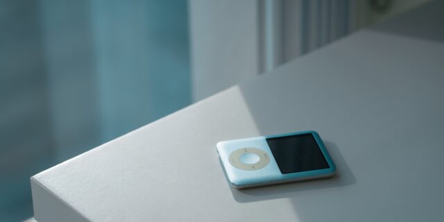 Ipod auf einem Schreibtisch. Durch ein Fenster scheint die Sonne auf den Tisch.
