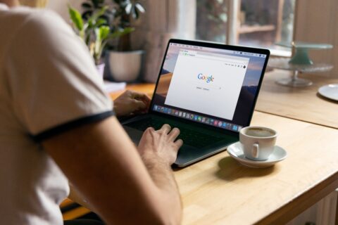 Blick über die Schulter auf einen Laptop Bildschirm, auf dem Google geöffnet ist.