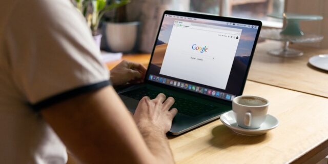 Blick über die Schulter auf einen Laptop Bildschirm, auf dem Google geöffnet ist.