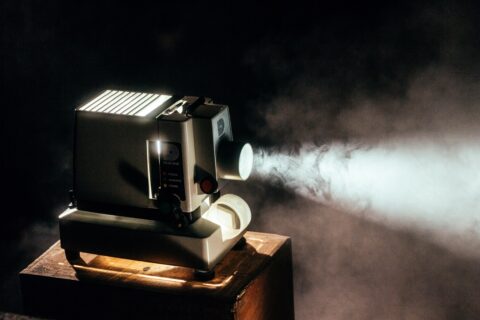 Ein Filmprojektor, der einen Lichtstrahl wirft und Staub sichtbar macht
