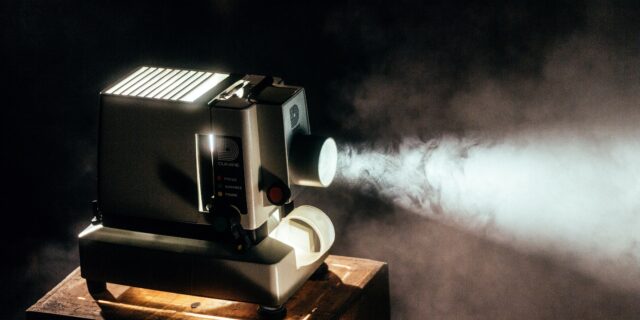 Ein Filmprojektor, der einen Lichtstrahl wirft und Staub sichtbar macht