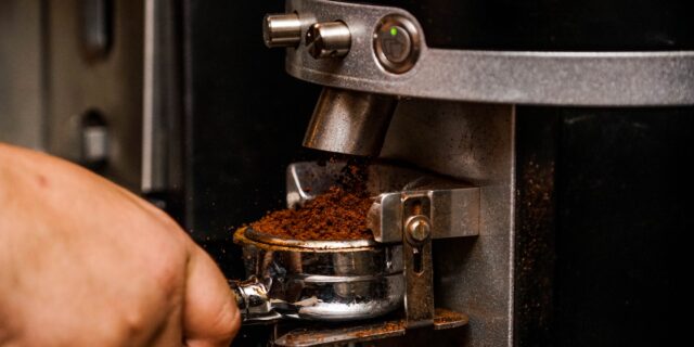 Jemand bedient eine Espresso-Kaffeemaschine