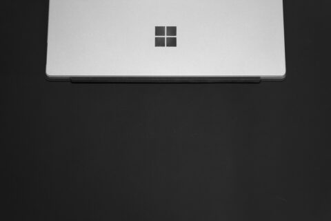 Schwarz-weiss-Bild, ein zugeklapptes Windows Notebook liegt auf einem dunklen Hintergrund.