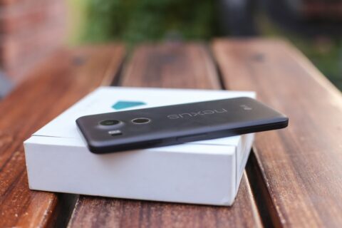 Ein Nexus Handy liegt auf der Verpackungsschachtel auf einem Holztisch