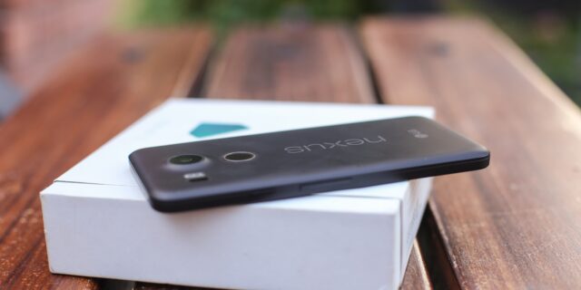 Ein Nexus Handy liegt auf der Verpackungsschachtel auf einem Holztisch
