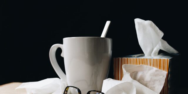Tisch mit Nastüchern, einer Tasse und einer Brille