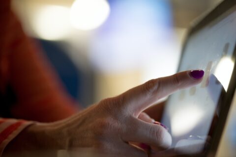 Zeigefinger einer Person auf Touchscreen