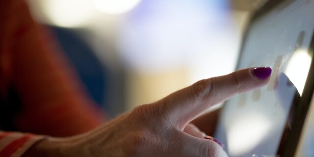 Zeigefinger einer Person auf Touchscreen