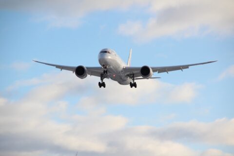 Grosses Flugzeug im Landeanflug, im Hintergrund ist ein bewölkter Himmel