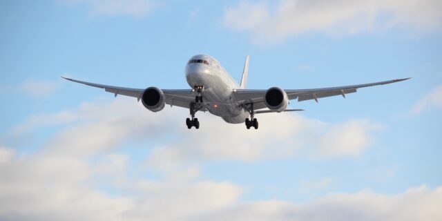 Grosses Flugzeug im Landeanflug, im Hintergrund ist ein bewölkter Himmel