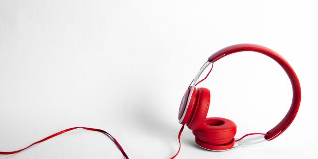 Rote Bügelkopfhörer mit Kabel auf weissem Hintergrund